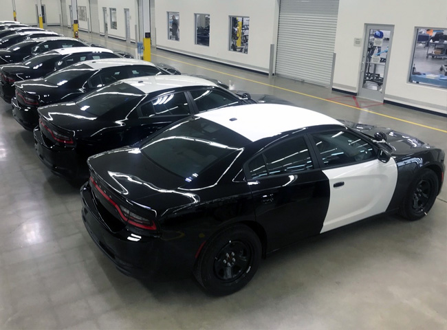 painted squad cars parked in shop